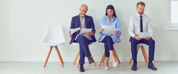 Open seat in a row of people sitting reviewing resumes