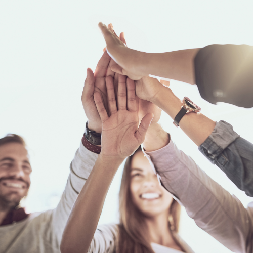 close up of five hands going together in a high-five position