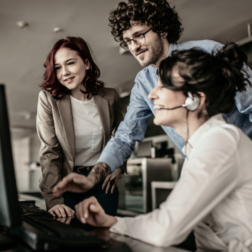 three younger professionals at a computer 